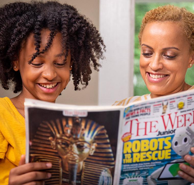 Mother and daughter smiling while reading the week junior magazine